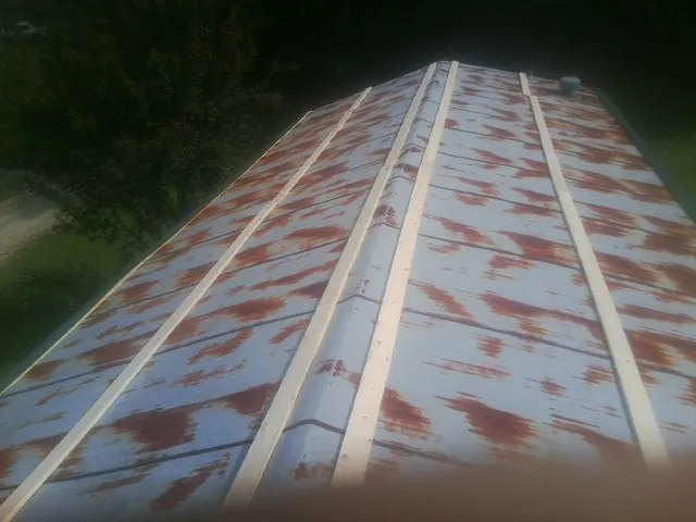 Rusted metal roof panels with new wood purlins before replacement — Storm Damage Roof Repair in Grand Junction by Roofing Brothers